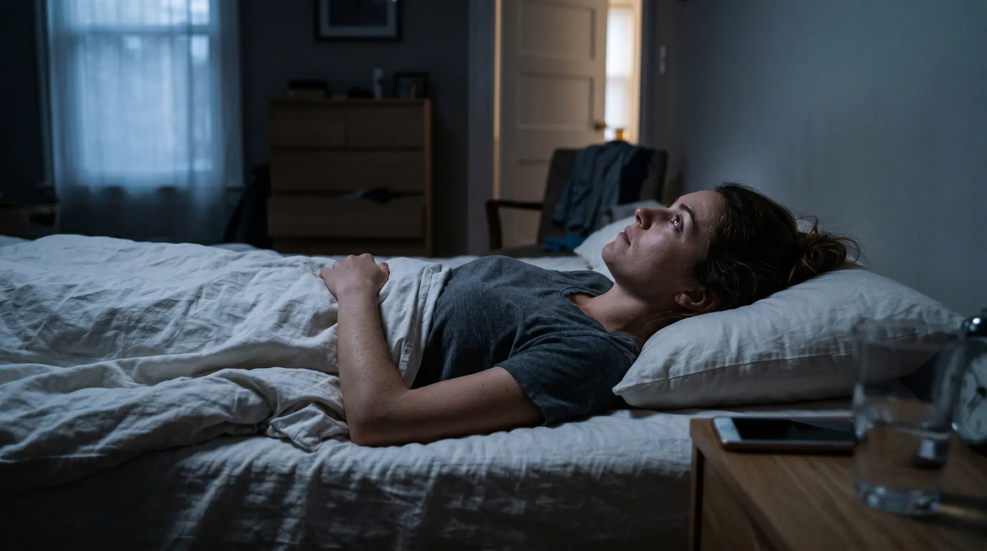 Person som ligger vaken i sängen mitt i natten på grund av stress